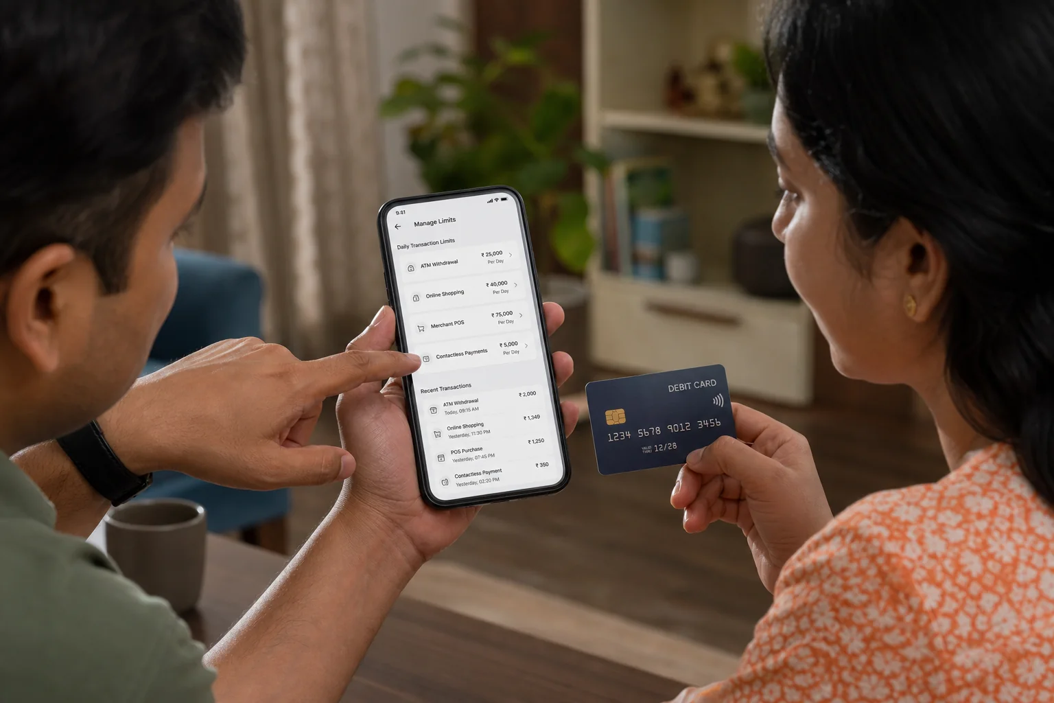 Indian couple reviewing debit card transaction settings for ATM, online, merchant POS, and contactless payments on a phone